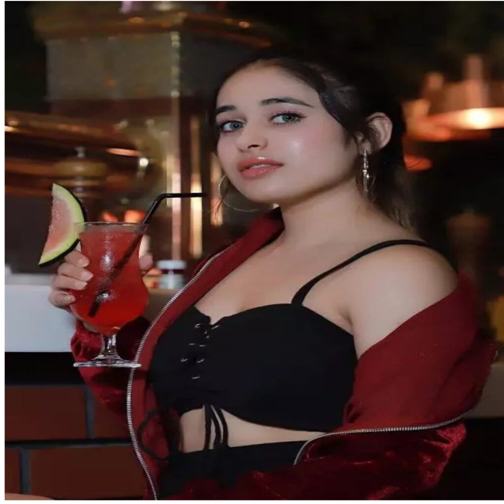 A GIRL 24 YEARS OLD IN SEXY DRESS TAKING JUCE CLASS ON HER HAND STANDING POSITION